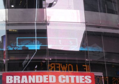 Branded Cities Werbeschild an einem modernen Gebäudefenster, reflektierende Glasfassade, städtische Umgebung, Werbung für innovative Stadtmarken, hochwertige visuelle Präsentation, urbanes Marketing, Großstadtwerbung.