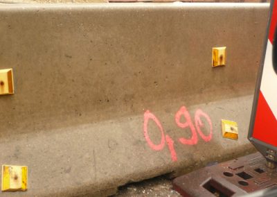Schallschutzwand auf einer Baustelle mit Graffiti in rosa, deutsche Bau- und Schalldämmtechnik, innovative Lärmschutzlösungen für Bauprojekte.