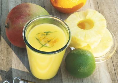 Frischer Fruchtcocktail mit Zitrone, Limette, Mango und Ananas für gesunden Vitaminboost.