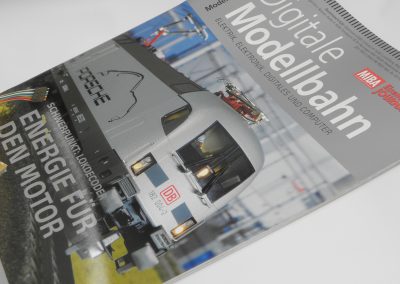 Modellbahn-Zeitschrift Cover mit einem elektrischen Modellbahnwagen auf Schienen, Fokus auf Digitalisierung, Elektronik und Computerelektronik im Modellbahn-Sektor.