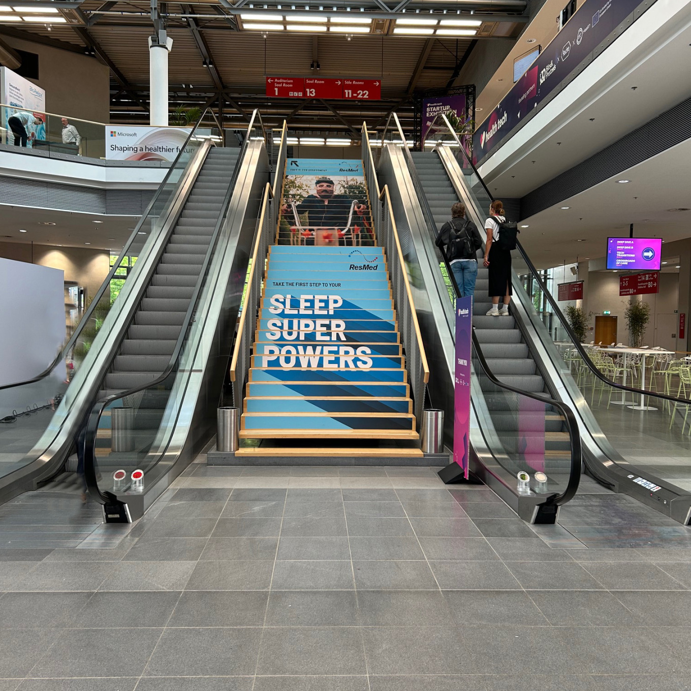 Flughafen escalator mit werbung für schlafförderung, moderne inneneinrichtung, werbung für gesunden schlaf, kontrastreiche farben, öffentlicher ort, industriearchitektur.