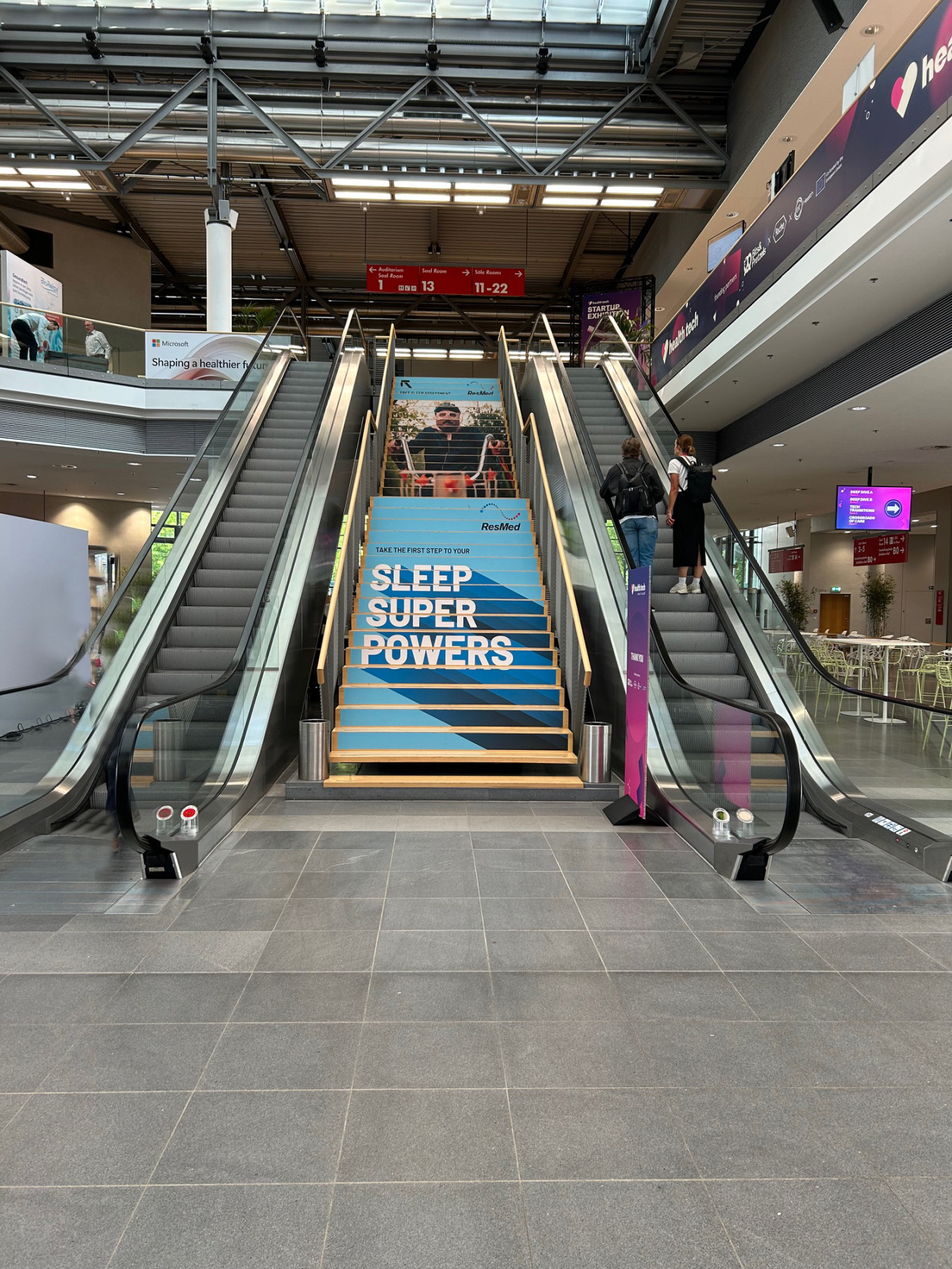 Flughafen escalator mit werbung für schlafförderung, moderne inneneinrichtung, werbung für gesunden schlaf, kontrastreiche farben, öffentlicher ort, industriearchitektur.