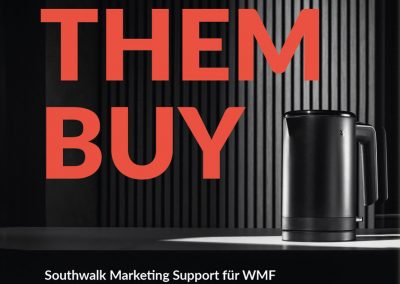 Edelstahl-Kaffeeautomat auf dunklem Hintergrund mit großen roten Texten "MAKE THEM BUY".