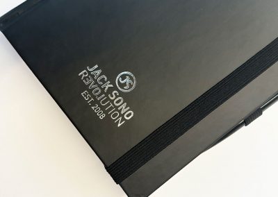 Hochwertiges schwarzes Notizbuch mit Silver-Relief-Logo von Jack Snow Revolution, ideal für Katzenliebhaber und kreative Notizen. Perfekt für stilvolles Schreiben und Sammeln.